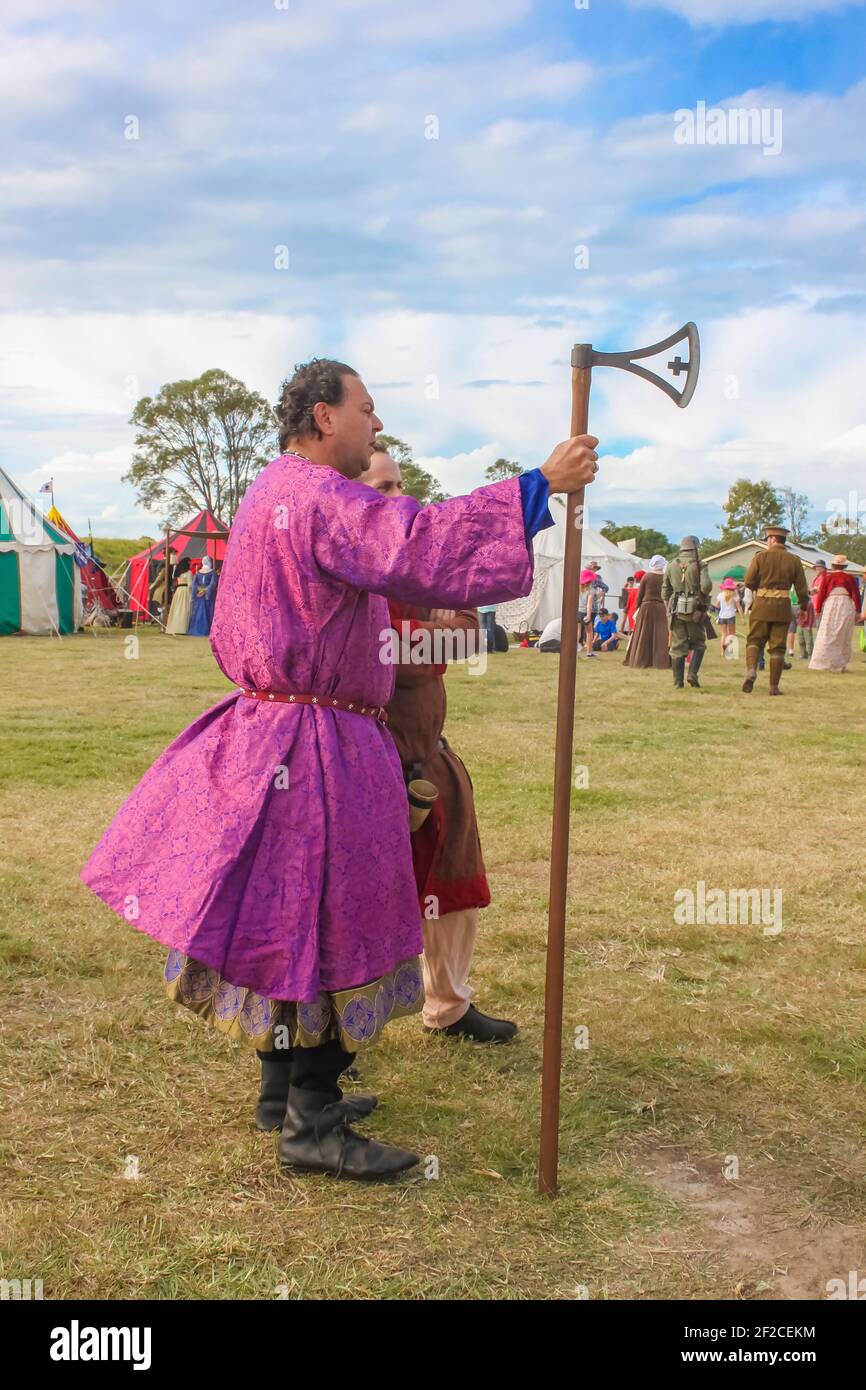 May 9 2014 Brisbane Australia - Man dressed in purple ornate robe holding late Scandinavian Viking cross axe at Living History re-enactment with peopl Stock Photo