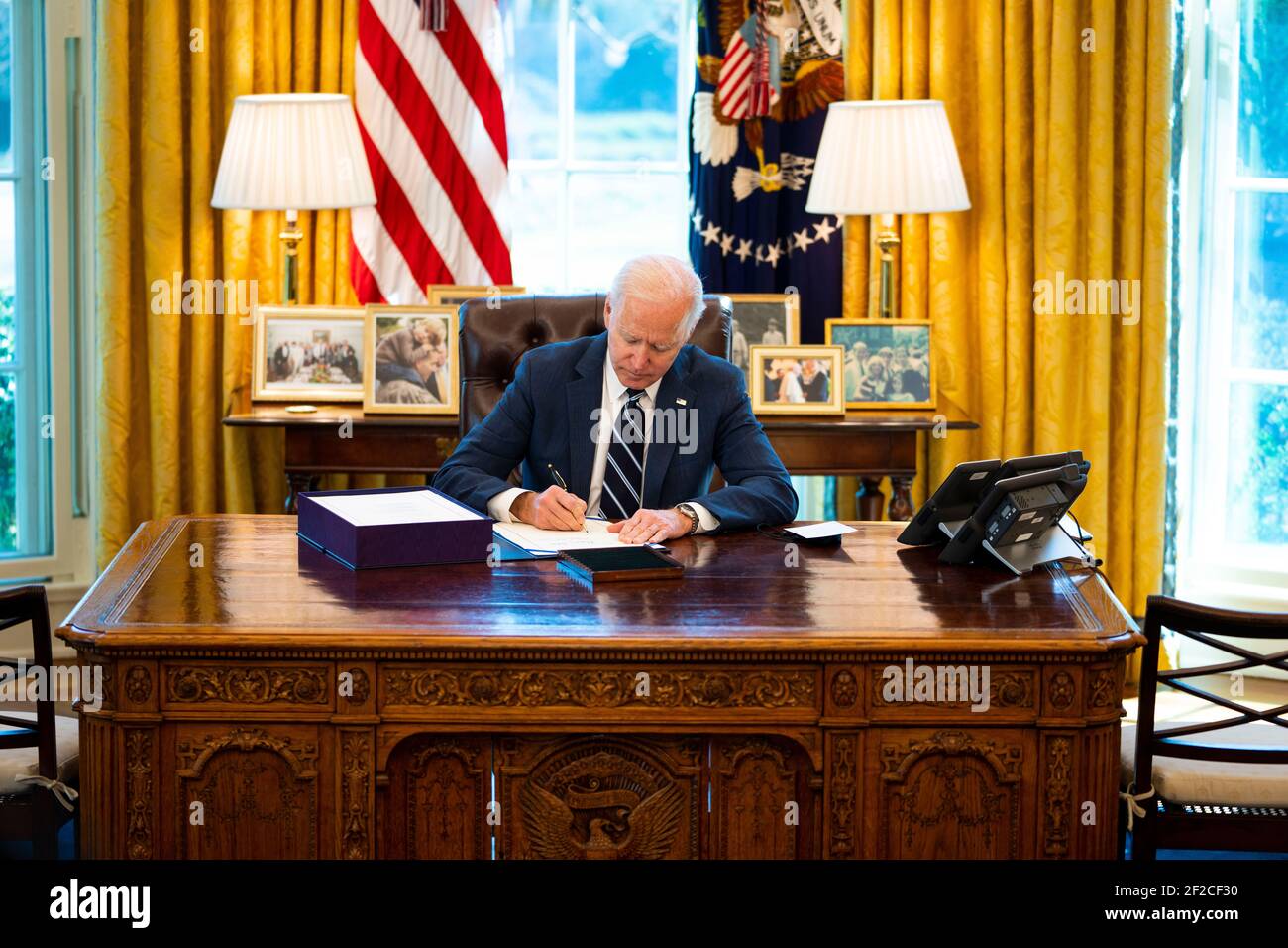 Washington, United States Of America. 11th Mar, 2021. United States President Joe Biden signs the American Rescue Plan with Vice President Kamala Harris looking on in the Oval Office, Thursday, March, 11, 2021. Credit: Doug Mills/Pool via CNP | usage worldwide Credit: dpa/Alamy Live News Stock Photo