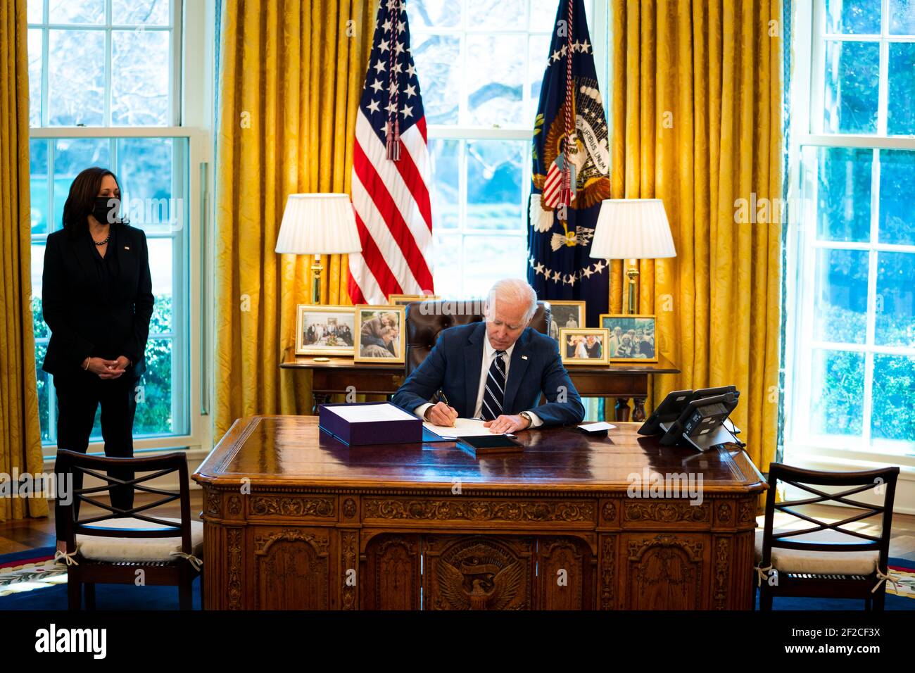 Washington, United States Of America. 11th Mar, 2021. United States President Joe Biden signs the American Rescue Plan with Vice President Kamala Harris looking on in the Oval Office, Thursday, March, 11, 2021. Credit: Doug Mills/Pool via CNP | usage worldwide Credit: dpa/Alamy Live News Stock Photo
