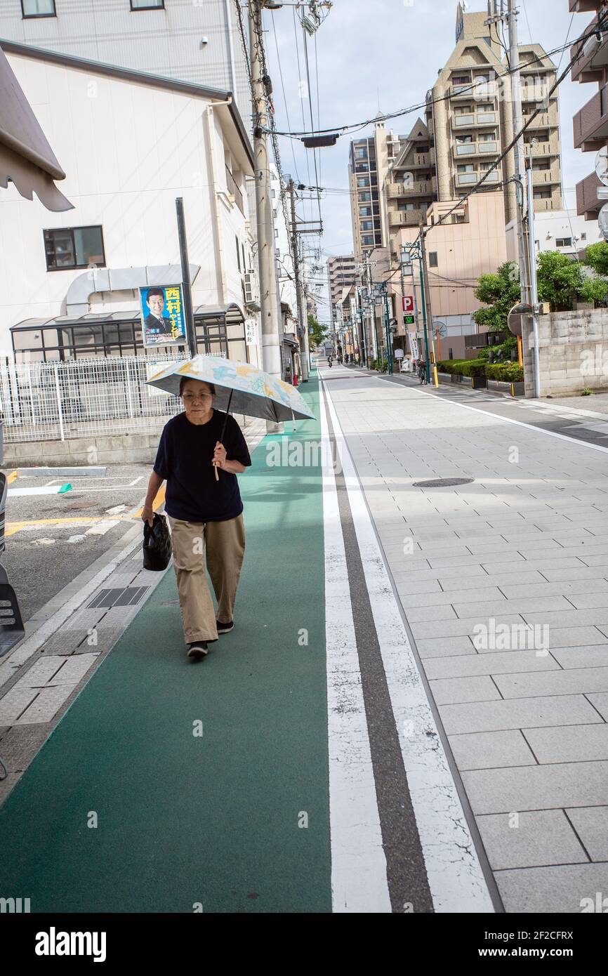 Single woman with umbrella in street , Akashi ,Hyogo prefecture, Japan. Stock Photo