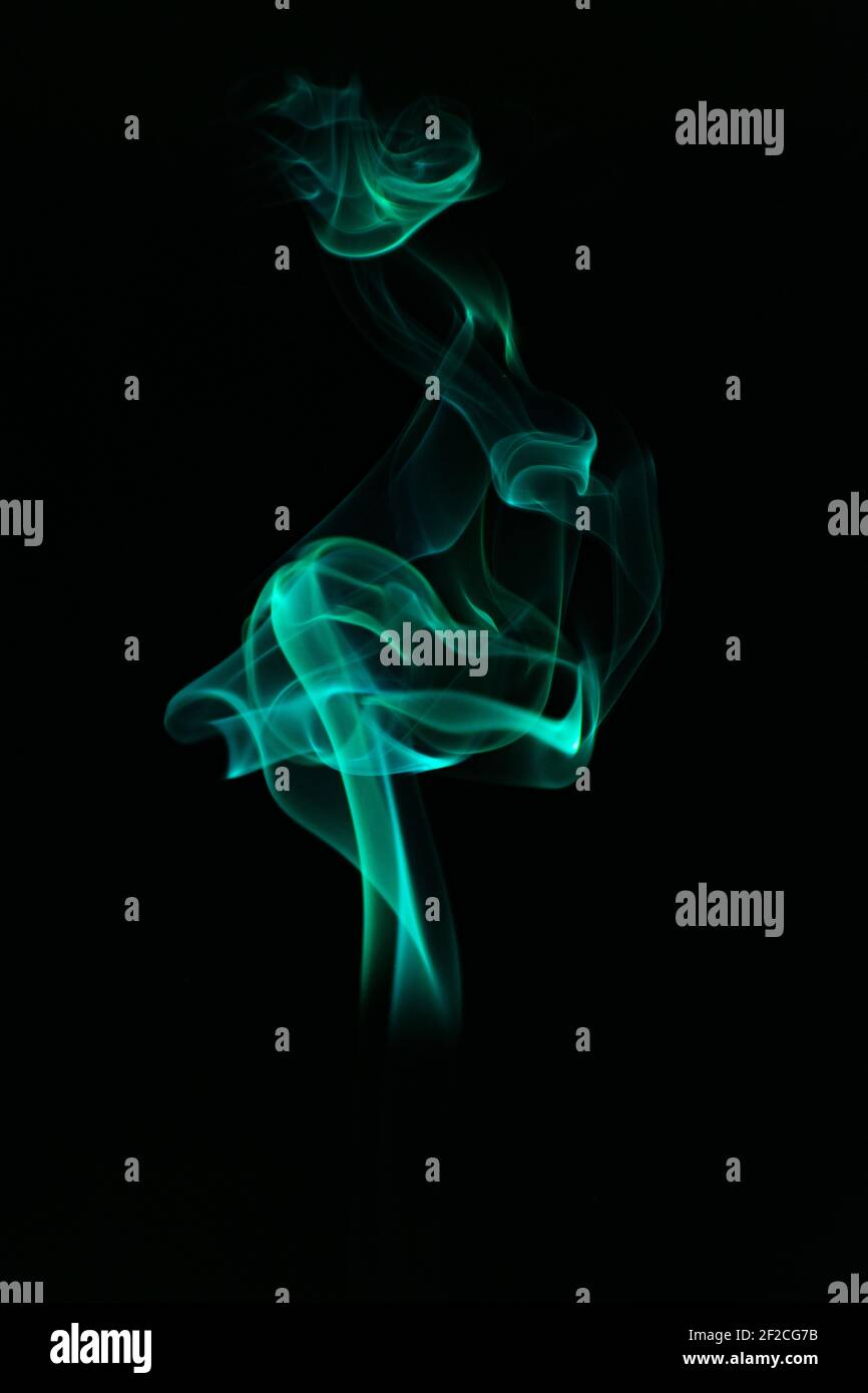 A vertical shot of a green smoke on an isolated black background Stock ...