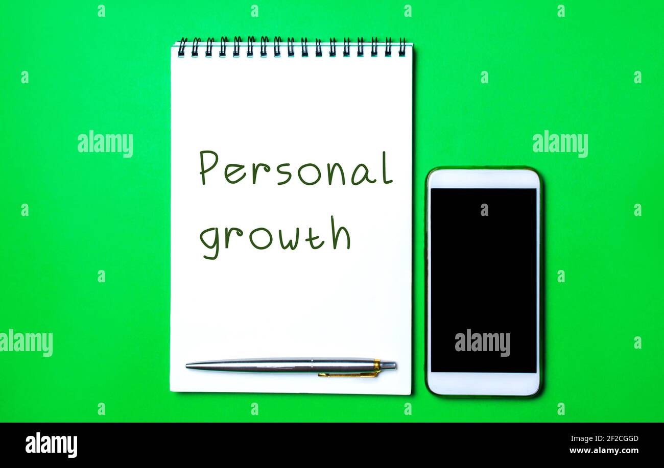 Notebook with the inscription Personal growth, a pen and a telephone. Self-improvement of skills, knowledge, personal qualities and life goals. Motiva Stock Photo
