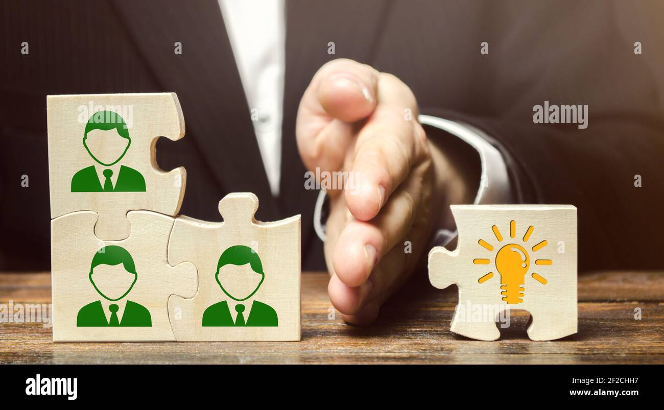 Wooden puzzles with icons of employees and business idea. Concept of new ideas and discoveries. Cooperation teamwork. Achieving goal. Innovation, coll Stock Photo