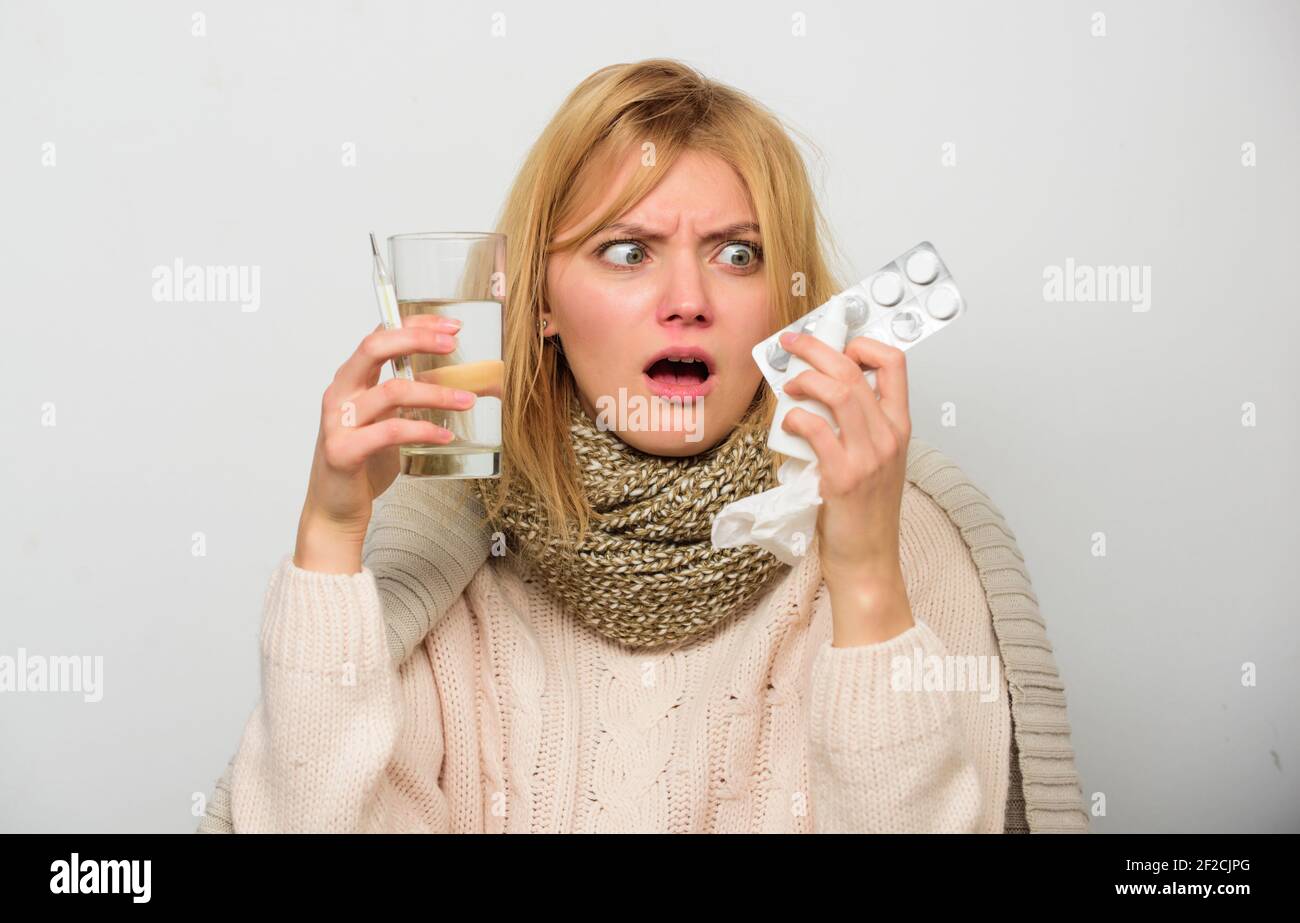 Getting fast relief. Ways to feel better fast. Flu home remedies. Get rid of flu. Woman wear warm scarf because illness or flu. Girl hold glass water Stock Photo