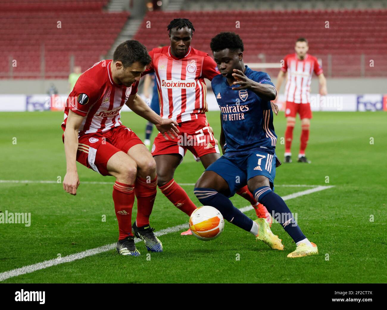 Soccer Football - Europa League - Round of 16 First Leg - Olympiacos v  Arsenal - Karaiskakis Stadium, Piraeus, Greece - March 11, 2021 Arsenal's  Bukayo Saka in action with Olympiacos' Sokratis Papastathopoulos  REUTERS/Alkis Konstantinidis Stock Photo ...