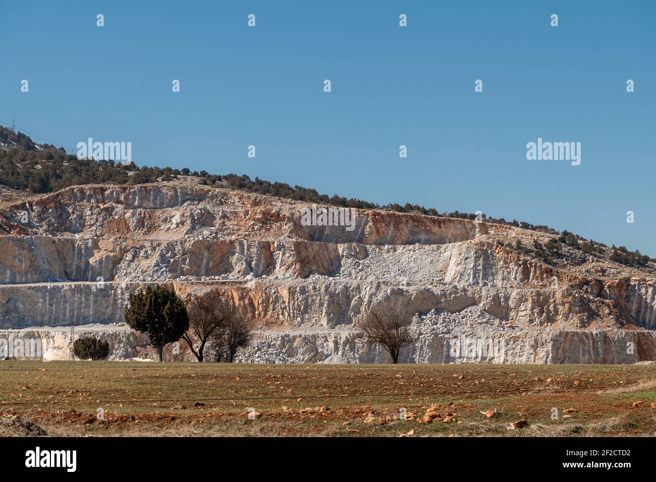 Rock quarry mining for gravel and limestone with blast marks showing on the sides of steep walls Stock Photo