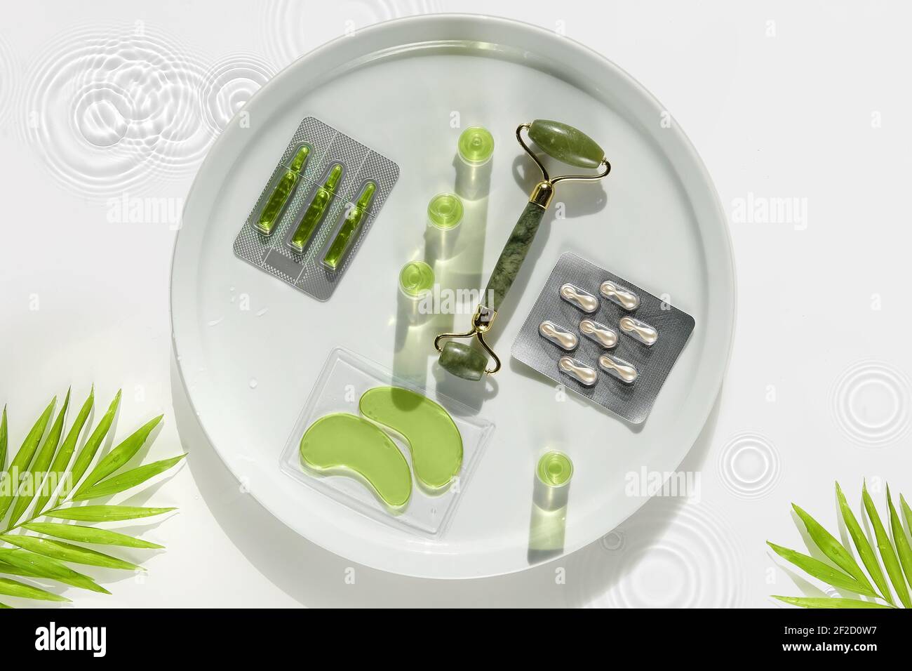 Cosmetic skincare background. Jade stone roller, Hyaluronic acid gel