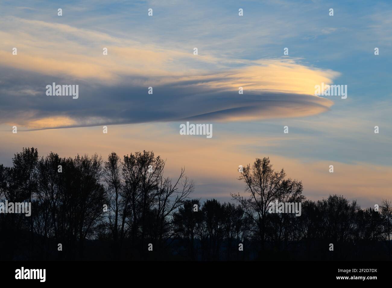 A lenticular cloud and tail stretches across the sky above the Snoqualmie Valley of Washington State Stock Photo