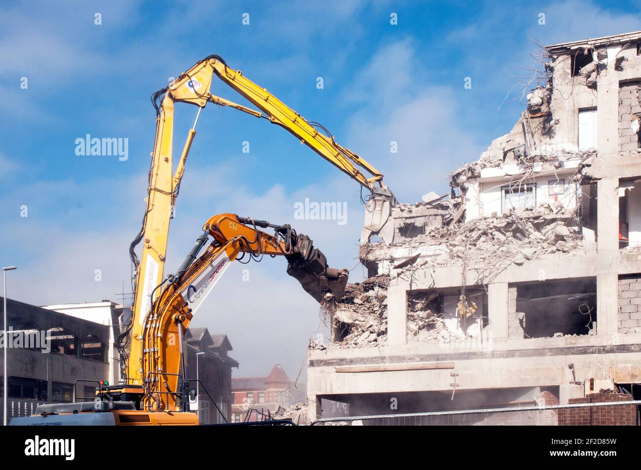 Large hydraulic jaws breaking up reinforced concrete at the demolition of Wilko store and multi storey car park Talbot Rd Blackpool Lancashire England Stock Photo