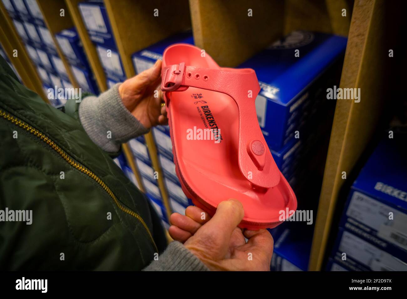 A shopper peruses the Birkenstock sandals displayed in a shoe store in New York on Friday, February 26, 2021. The French luxury brand LVMH has purchased a majority stake in the German sandal cobbler Birkenstock in a deal worth €4bn. (© Richard B. Levine) Stock Photo