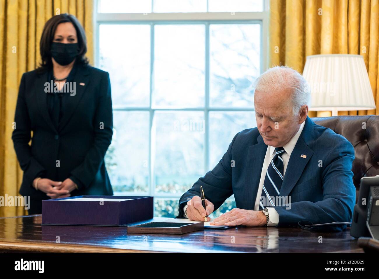 Washington, United States Of America. 11th Mar, 2021. U.S President Joe Biden signs the American Rescue Plan into law as Vice President Kamala Harris looks on in the Oval Office the White House March 11, 2021 in Washington, DC Credit: Planetpix/Alamy Live News Stock Photo
