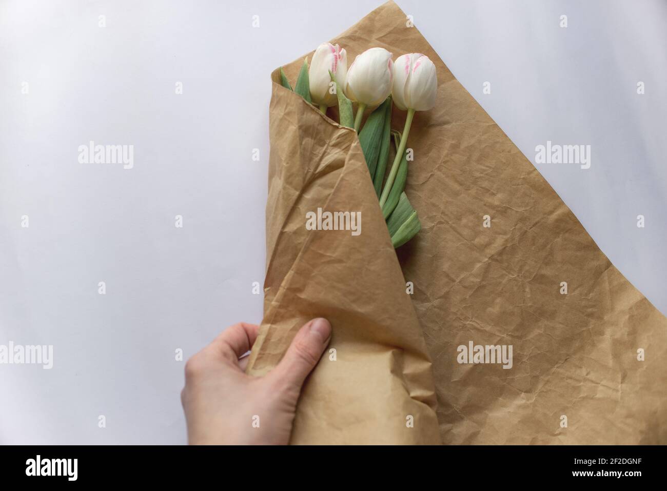 Hands of Caucasian woman wrapping bouquet in brown paper Stock Photo - Alamy