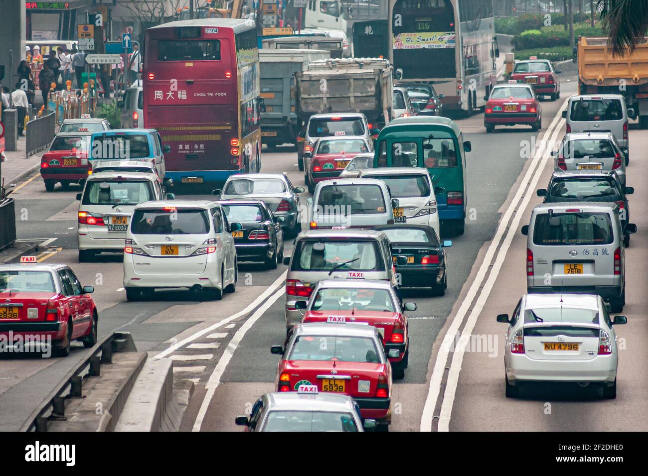 Hong Kong Island, China - May 14, 2010: Traffic on north side with multilane lines of cars, trucks, and double-decker public transport buses. Some ped Stock Photo