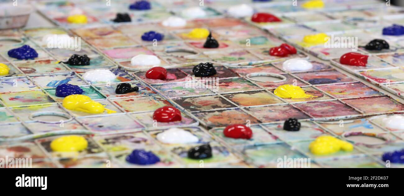 An arrangement of painting palettes set up ready for art class at school. Primary and secondary colours colors organised organized on a tray. creative Stock Photo