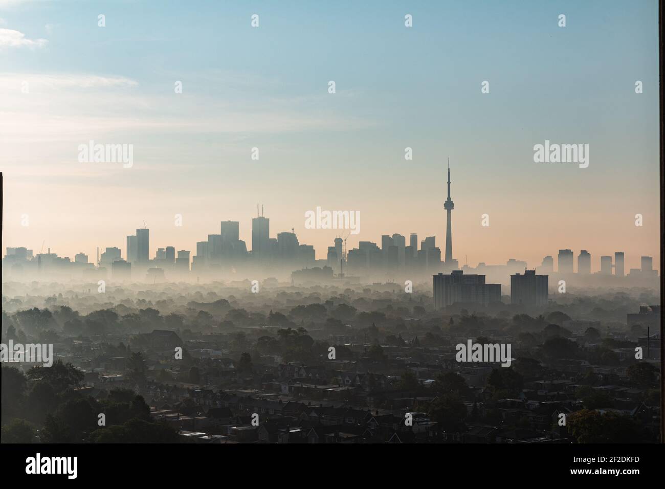 Skyline of Toronto with its CN Tower, seen from a skyscraper in the district The Junction on a foggy autumn morning during sunrise Stock Photo