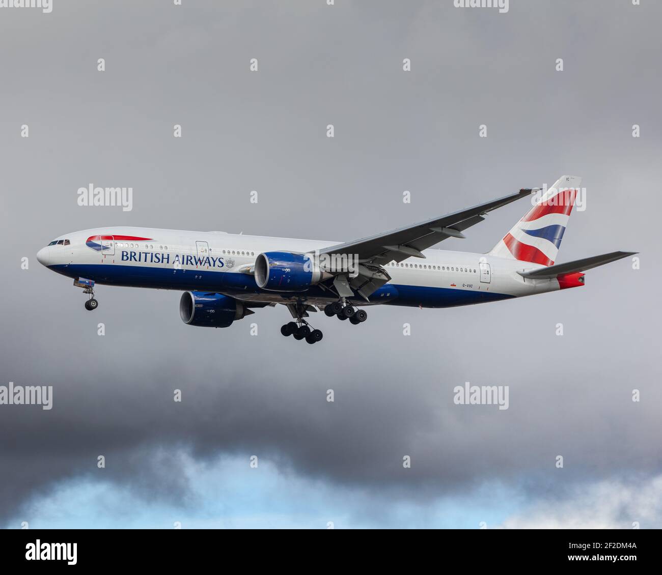 London, Heathrow Airport - March 2020: British Airways, Boeing 777, registration G-VIIC  Landing on runway 27L on a grey and stormy day. image Abdul N Stock Photo