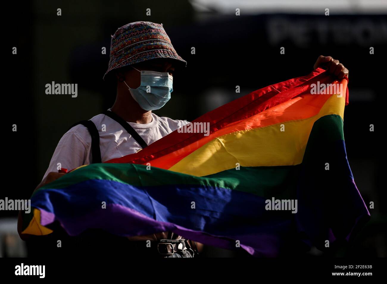 A woman holds a rainbow flag as members of an LGBT (Lesbians Gays Bisexual Transgender) group protest against the early release of US soldier Joseph Scott Pemberton at the Boy Scout Circle in Quezon City, Metro Manila, Philippines. Stock Photo