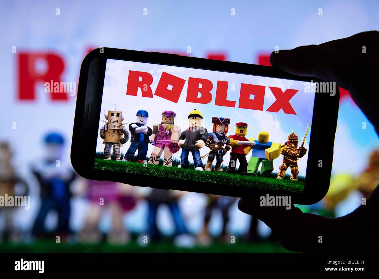 LONDON, UK - March 2021: Person holding a smartphone with Roblox game logo  Stock Photo