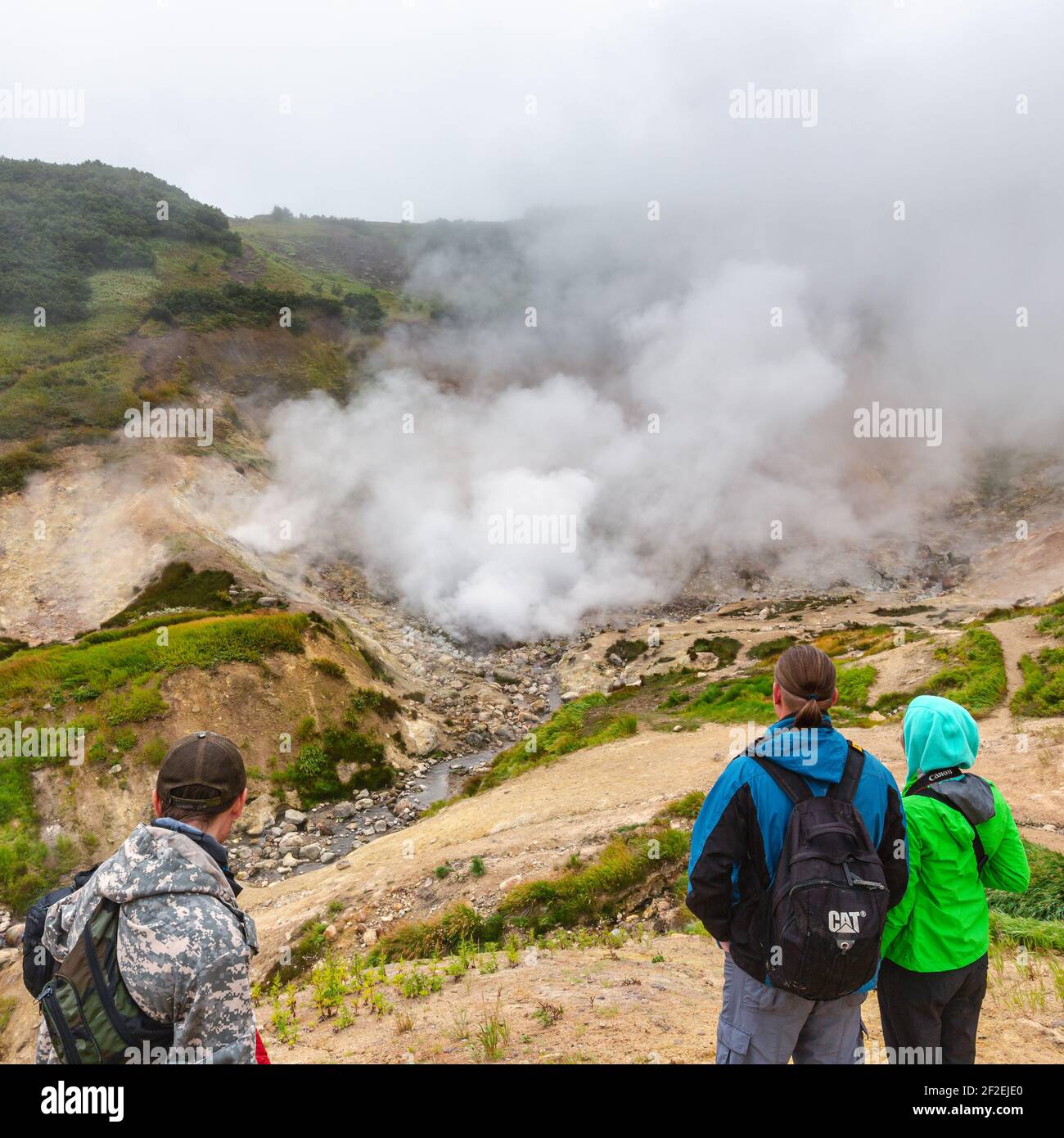 Group of travelers and tourists observes mysterious volcanic landscape ...