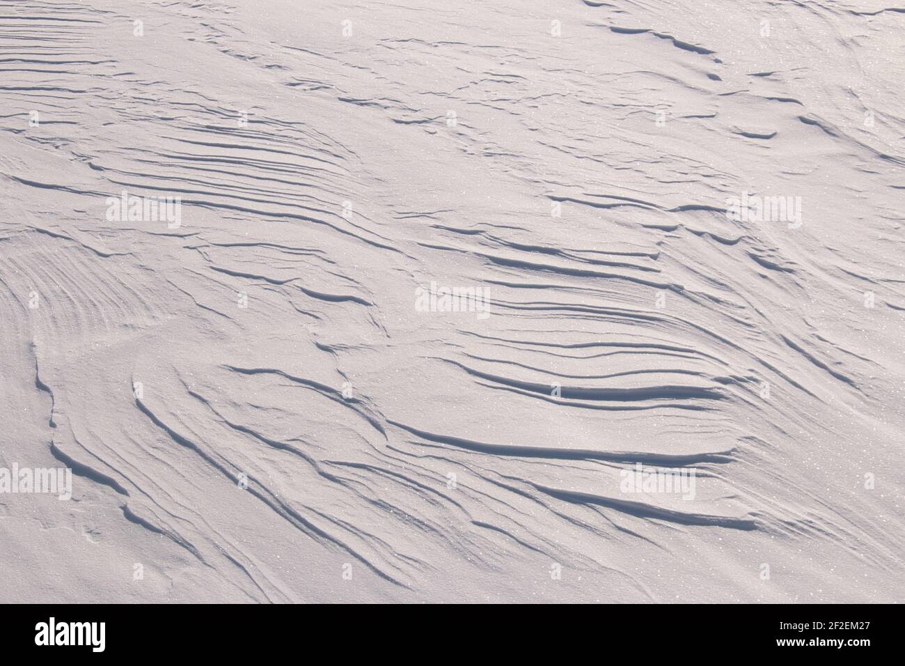 Random patterns in sparkling white snow created by the wind Stock Photo