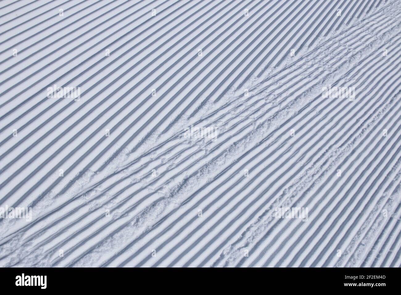 Parallel lines in freshly groomed snow at a ski resort Stock Photo