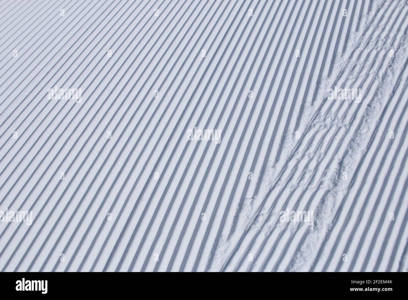 Parallel lines in freshly groomed snow at a ski resort Stock Photo