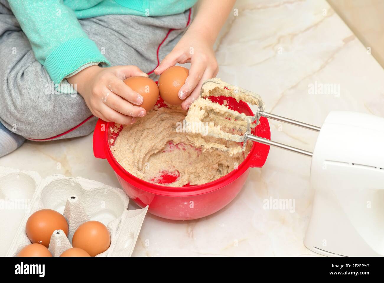 Child prepares dessert in the kitchen, detail Stock Photo