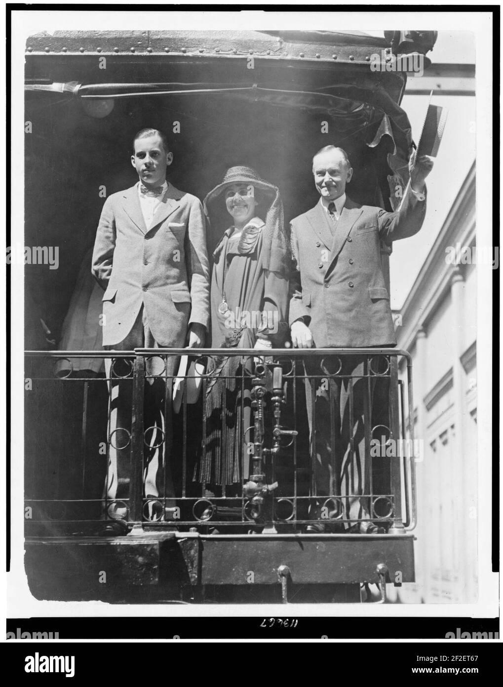 President Calvin Coolidge, full-length portrait, standing, facing slightly left, with wife and son, on back of railroad train Stock Photo