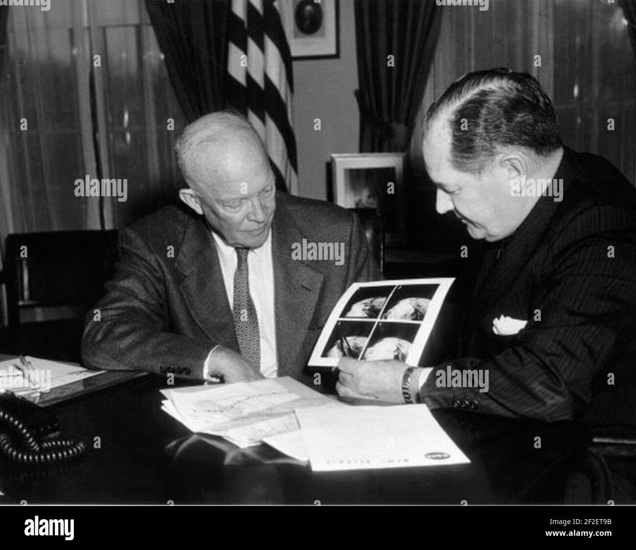 President Eisenhower and NASA Administrator Glennan examine photographs taken by TIROS-1. Stock Photo