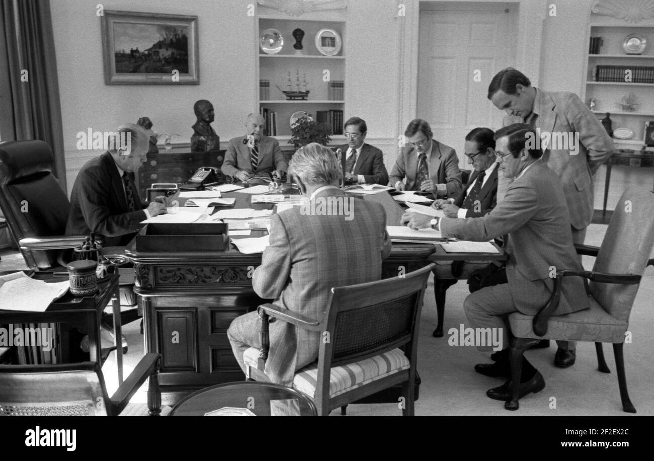 President Gerald Ford and staff review a draft of his address to the Nation on recommendations for tax reduction and spending. Stock Photo