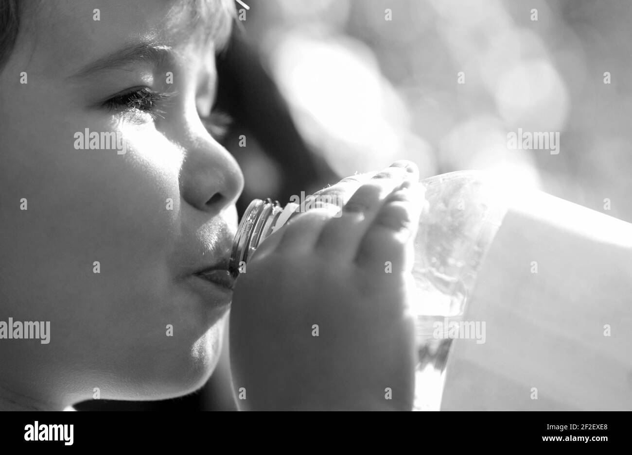 Young boy holding drink fresh water bottle. A child drinks water from a bottle, baby health. Portrait of a boy with a bottle of mineral water. Boy Stock Photo