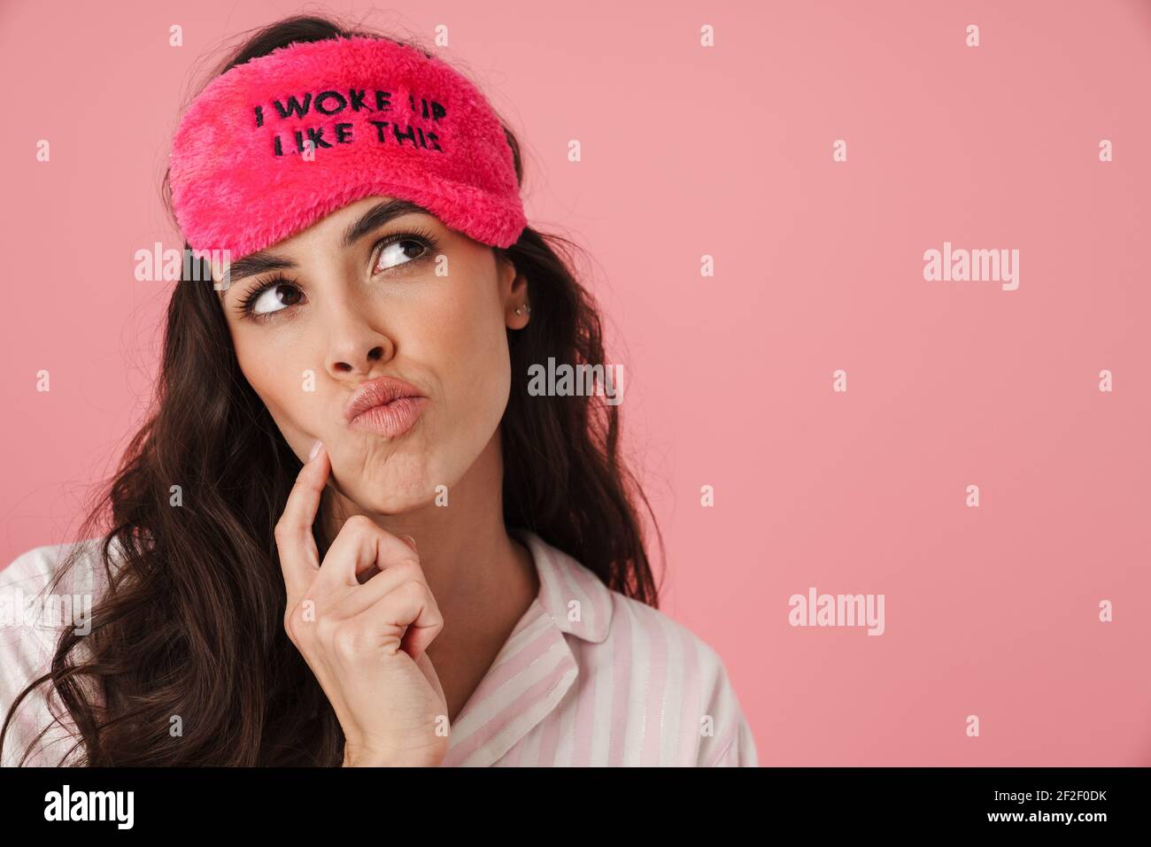 Thinking beautiful woman in sleeping mask looking upward isolated over ...
