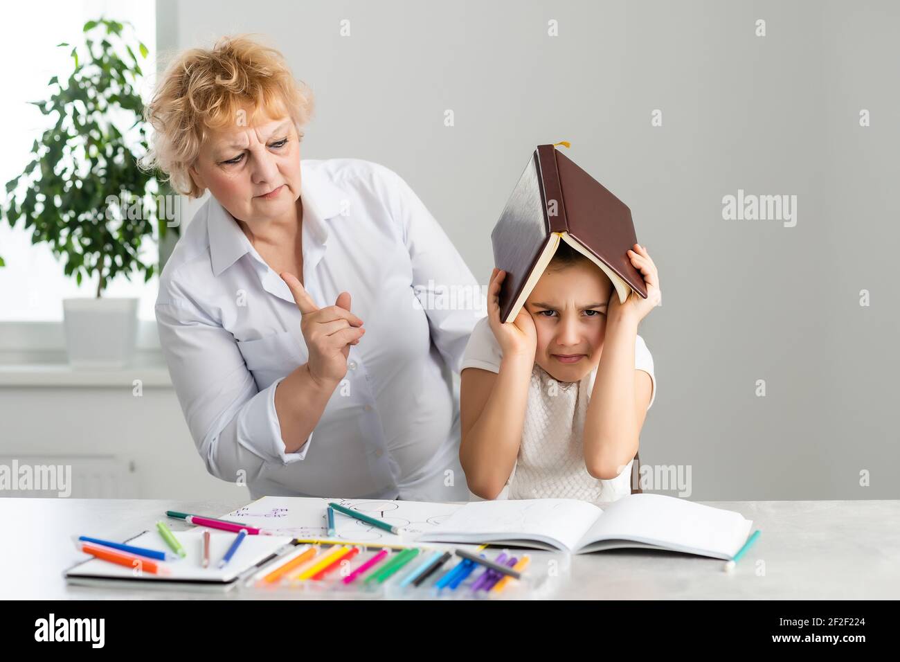 Mid aged grandmother scold grown up granddaughter, angry grandmother tell complaints lecturing child feeling stressed, misunderstandings, generational Stock Photo