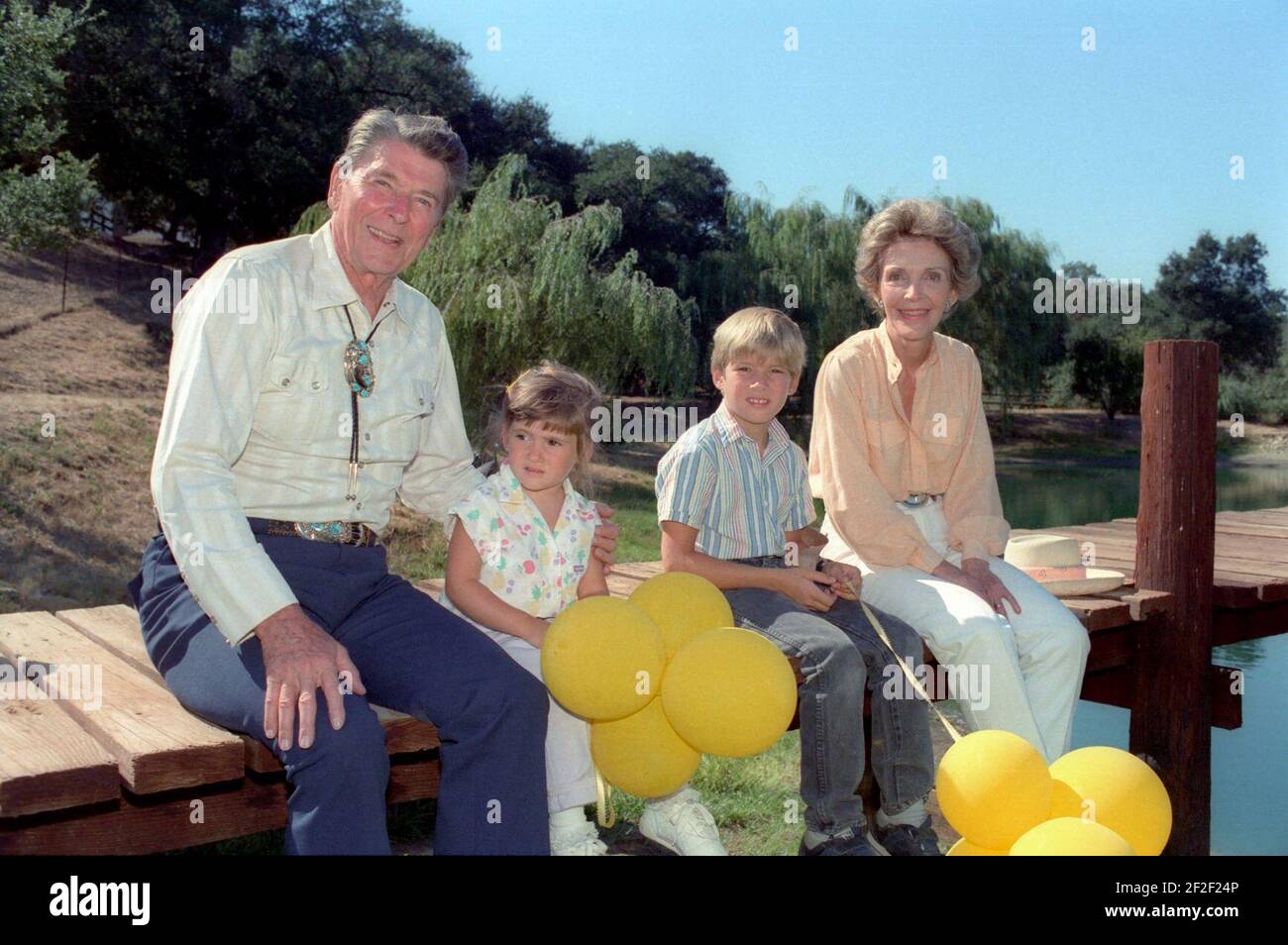 President Ronald Reagan And Nancy Reagan Sitting On The Dock With Their   President Ronald Reagan And Nancy Reagan Sitting On The Dock With Their Grandchildren Cameron Reagan And Ashley Marie Reagan 2F2F24P 