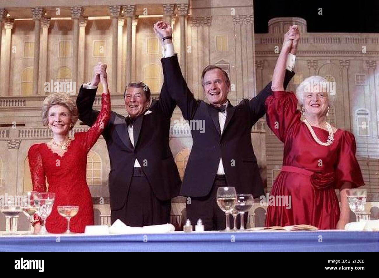 President Ronald Reagan and Vice President George Bush, accompanied by wives Nancy and Barbara, join hands after the President endorses Bushes run for the Presidency during the President's dinner, Washington, DC. Stock Photo