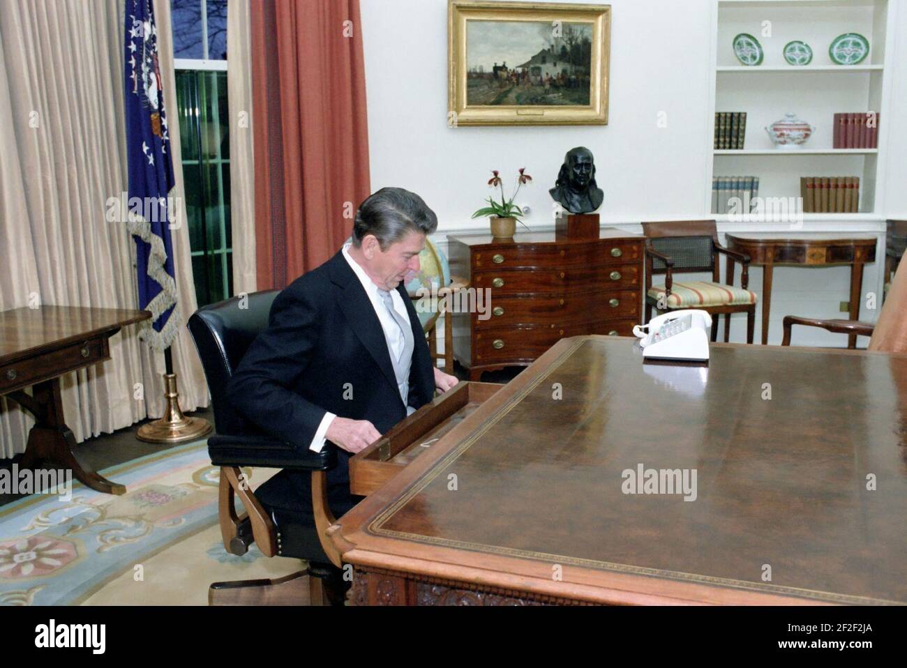 President Ronald Reagan checking his desk during his first day in the
