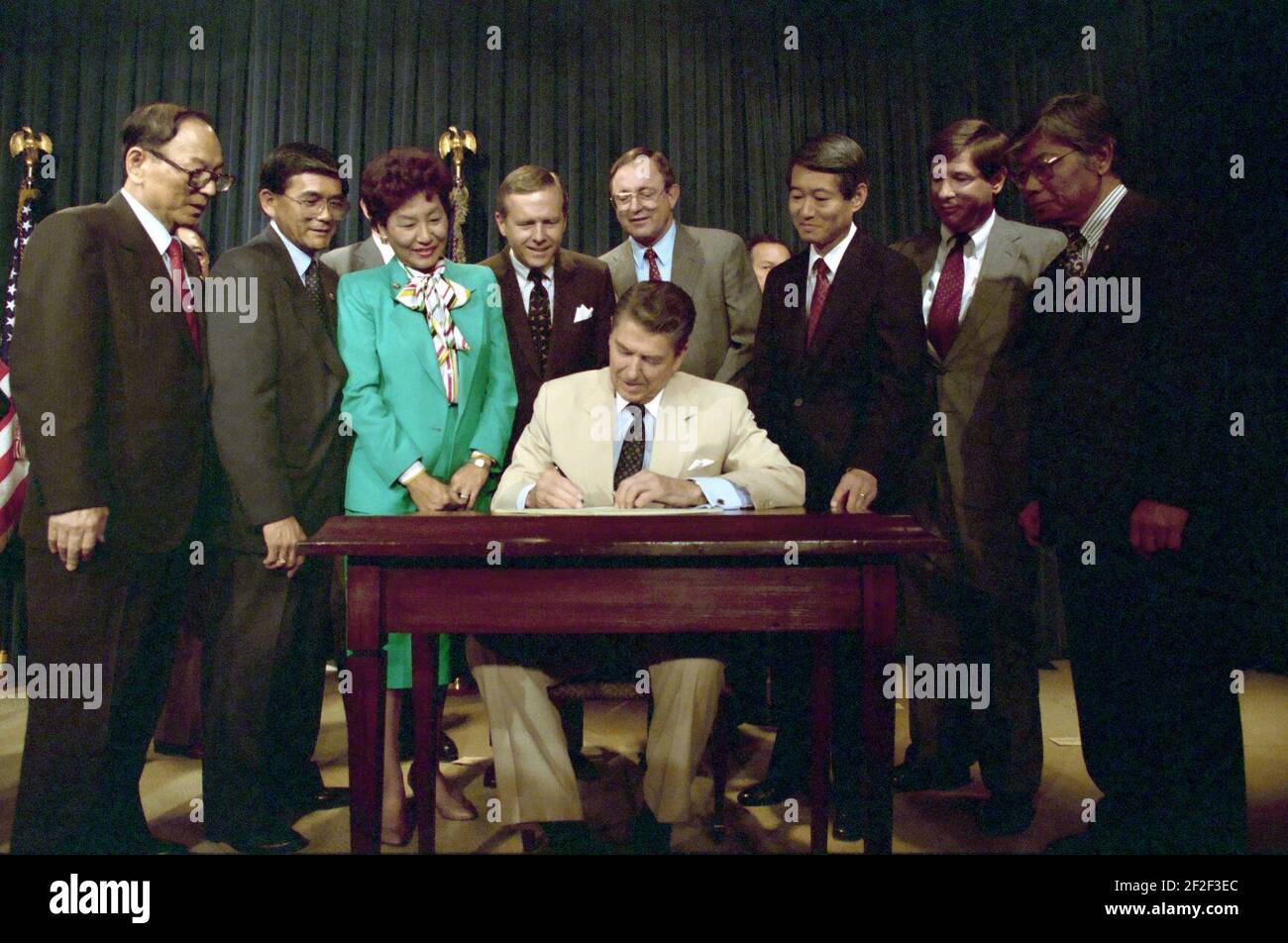 President Ronald Reagan signs the Reparations Bill for Japanese-Americans. Stock Photo