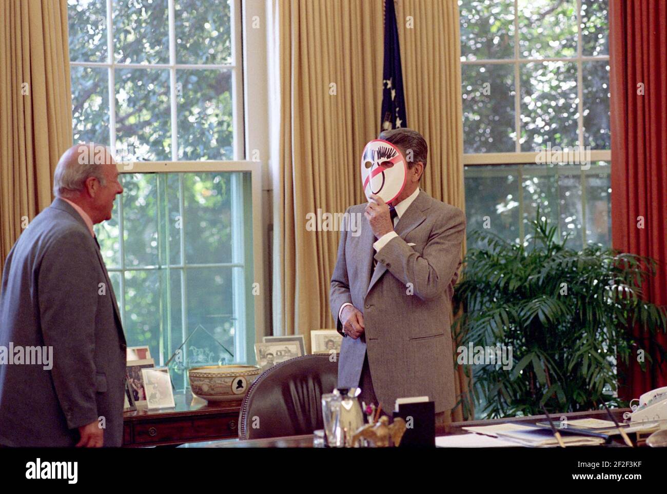 President Ronald Reagan Wearing An Anti Dukakis Mask And Showing George Shultz In The Oval