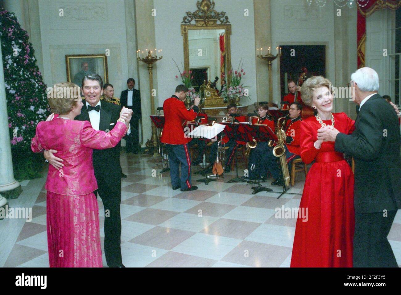President Ronald Reagan, Margaret Thatcher, Nancy Reagan, and Denis Thatcher dancing in the Cross Hall. Stock Photo
