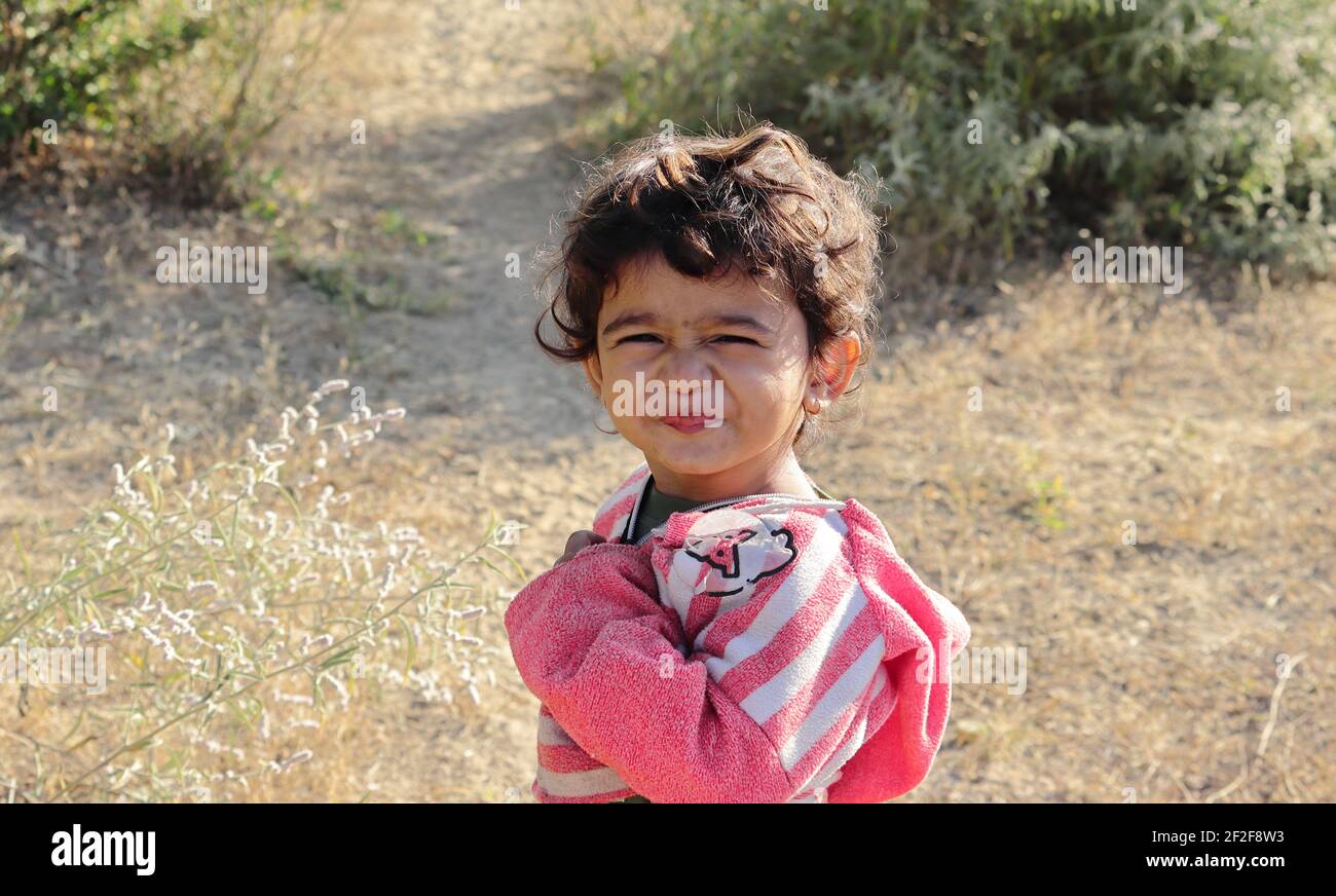 A young boy of Indian origin standing in the garden expressing his sourness. concept for Today's children tomorrow's future, childhood memories, smile Stock Photo