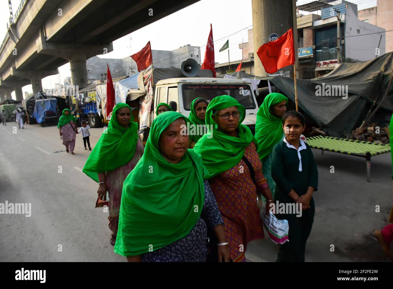 March 8, 2021: New Delhi, India. 08 March 2021. Female farmers join a farmers' protest at the Tikri border near New Delhi against the government's new farm laws, on International Women's Day. Thousands of women have joined the farmers' protests around Delhi on International Women's Day demanding the scrapping of the three farm bills passed by the Parliament of India in September 2020. Farmers and their families, as well as farmers unions, have been protesting for months to have the new agricultural laws repealed as they think they would open up the country's farm sector to corporatio Stock Photo