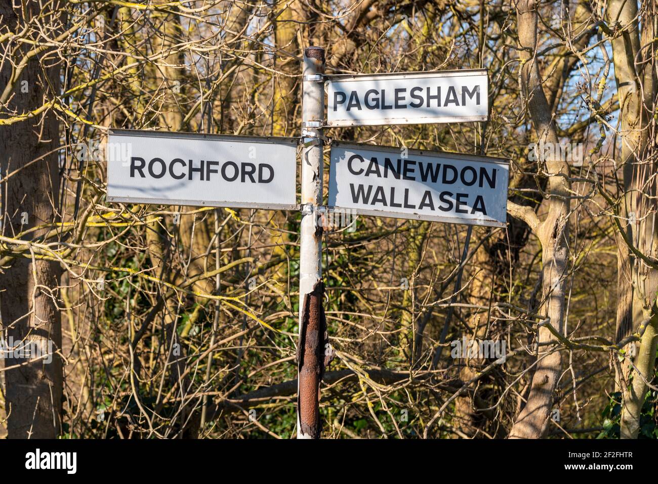 Old road destination sign in Ballards Gore, Stambridge, Essex, UK, with routes to Rochford, Paglesham, Canewdon and Wallasea. Woodland, rural places Stock Photo
