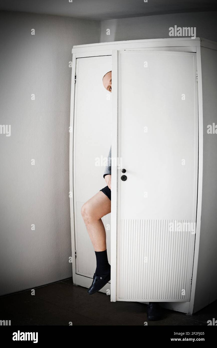 Man comes out of a wardrobe Stock Photo