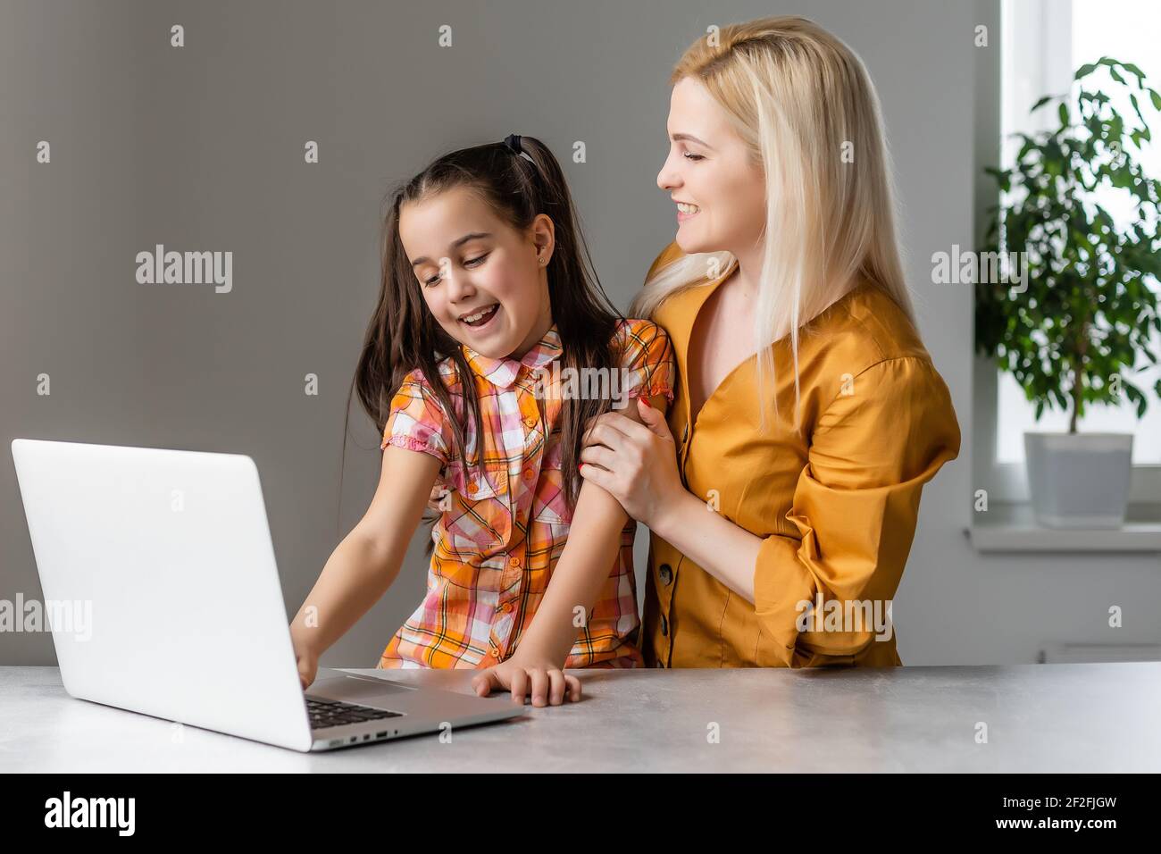 Helpful mother explaining to daughter about using a laptop Stock Photo
