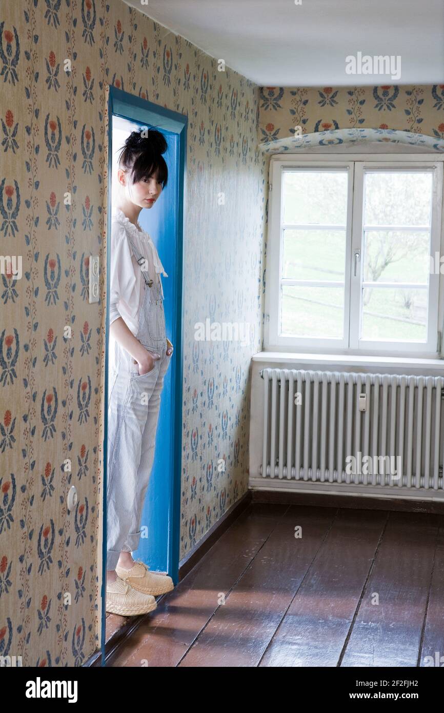 Woman stands on a doorstep in a room Stock Photo