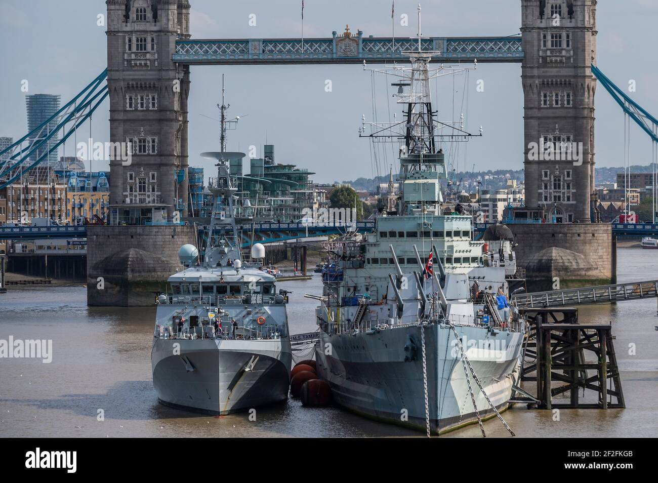 HMS Tamar a new patrol vessel is moored next to HMS Belfast on the