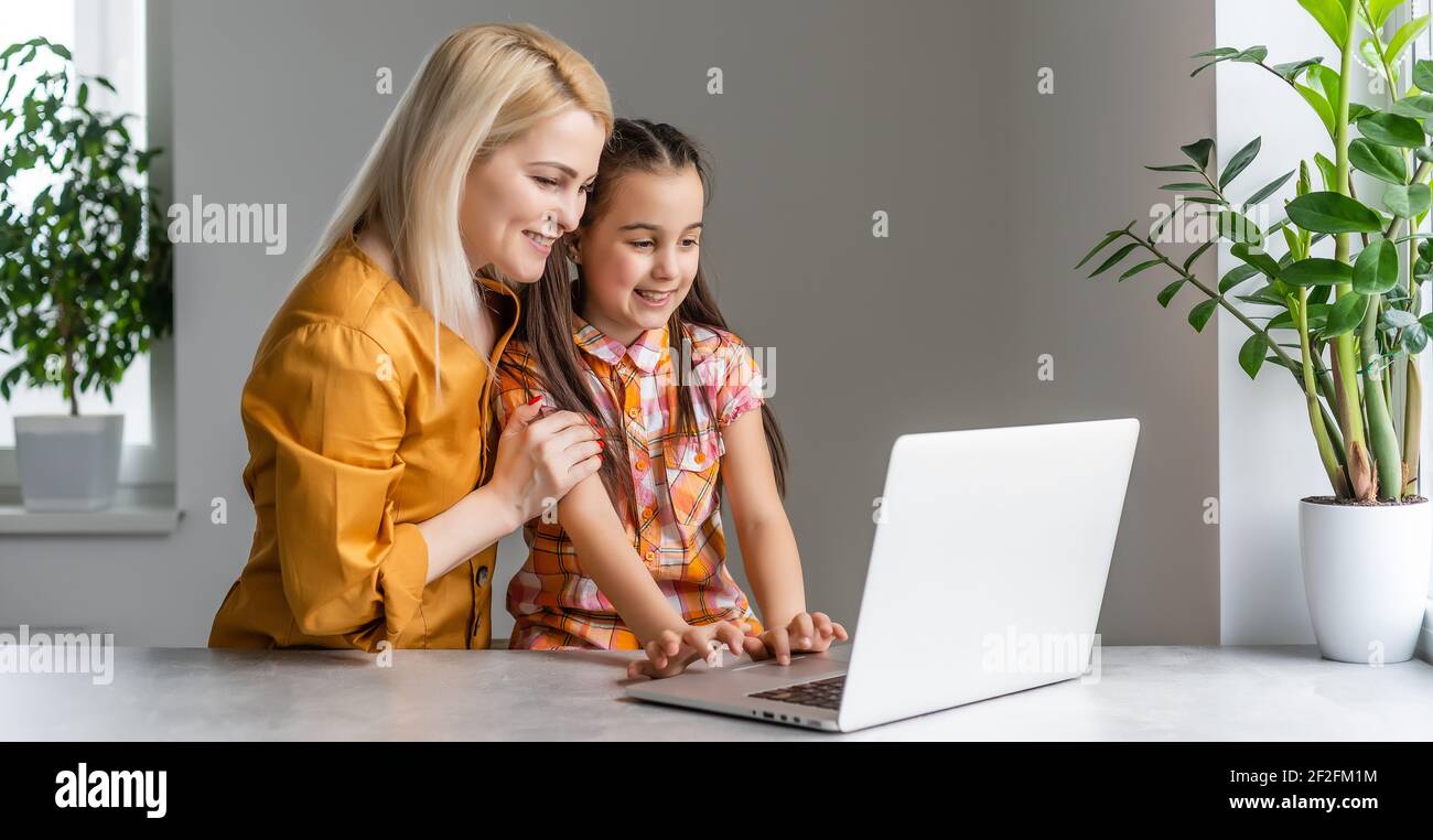 Helpful mother explaining to daughter about using a laptop Stock Photo