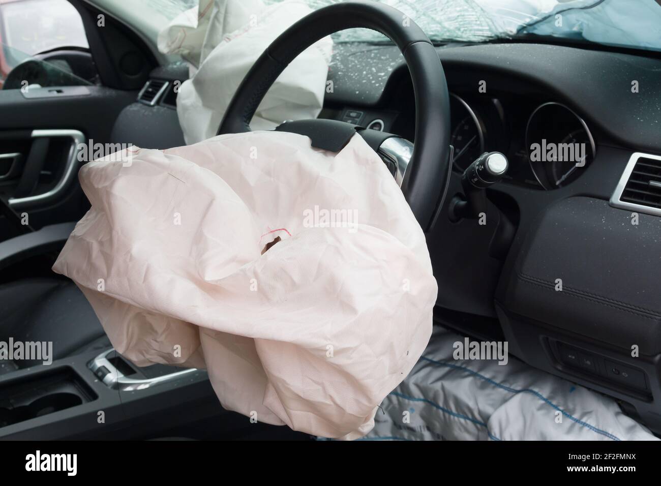 Interior of a automobile or car involved in a vehicle crash with a deployed steering column airbag Stock Photo