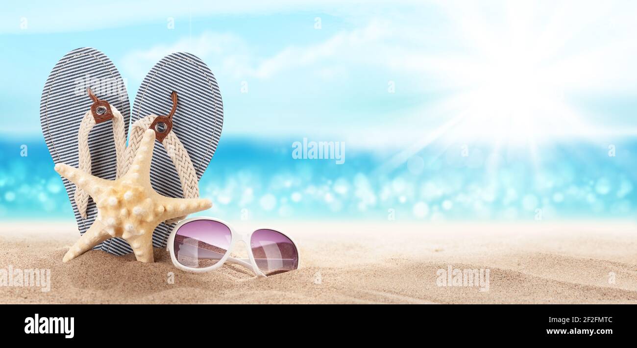 Flip flops, starfish and sunglasses on sunny sea beach with copy space ...