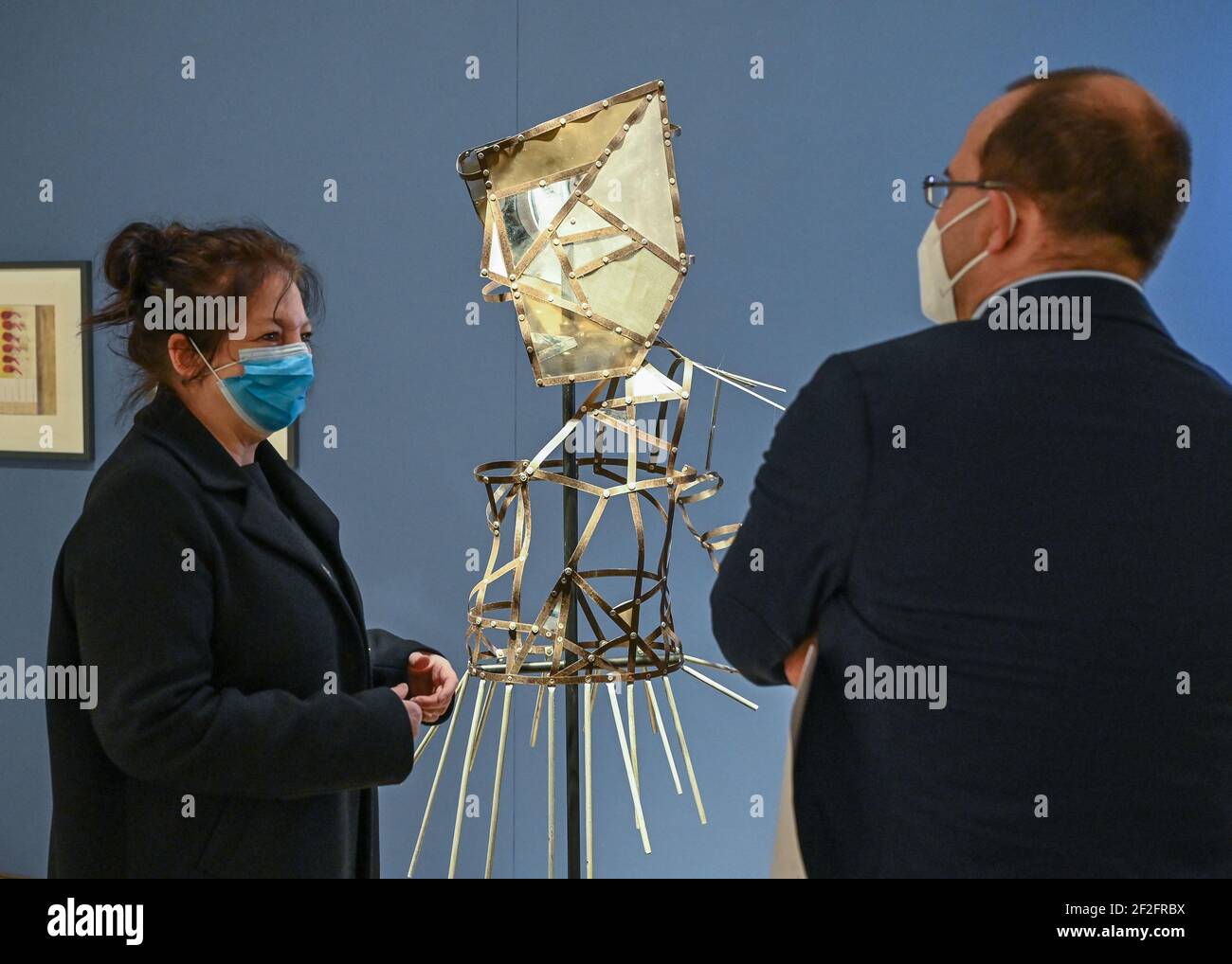 12 March 2021, Brandenburg, Frankfurt (Oder): Ulrike Kremeier, Director of the Brandenburg State Museum of Modern Art (BLMK), and Tobias Dünow, State Secretary for Science, Research and Culture of the State of Brandenburg, talk in front of the object 'The Newscaster' from 1989 by the artist Verena Kyselka. The BLMK took the first opportunity after 18 weeks of corona-related 'forced break' and has opened its doors to visitors again since 09.03.2021. The special opening hours at the locations in Cottbus and Frankfurt (Oder) are Tuesdays to Sundays from 12 to 18 o'clock. Photo: Patrick Pleul/dpa- Stock Photo